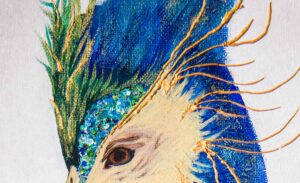 Image montant le détail du travail de la tête du sujet principal du tableau. Le paon. Peinture acrylique dans les tons de bleu, vert, et jaune. Ornée de sequin reflétant la lumière et de pâte à relief dorée.