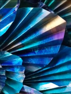 Détail de la colorisation à la peinture acrylique, bleu/vert, aux reflets violet et doré des feuilles qui constituent le plumage du sujet principal du tableau , le paon.